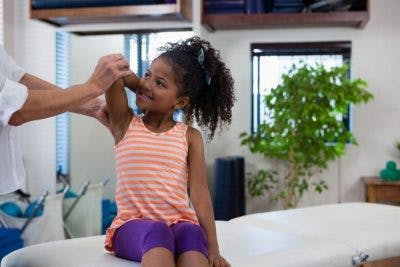 girl with cerebral palsy at physical therapy practicing stretches