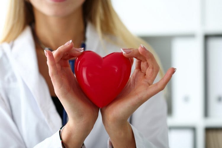 médecin tenant un coeur rouge entre ses mains pour symboliser la récupération de la main