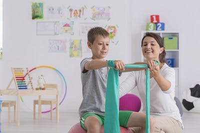 child with cerebral palsy practicing core-engaging exercises to promote better posture and balance