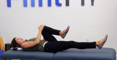 Physiothérapeute allongé montrant des exercices de réadaptation pour le tronc