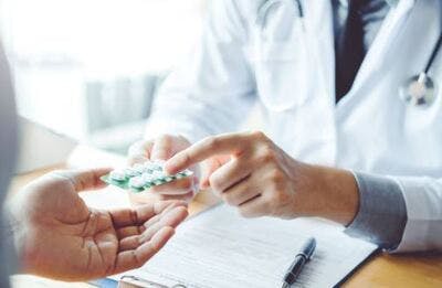 Médecin remettant une plaquette d'aspirine à un patient d'AVC