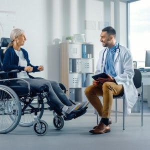 woman in a wheelchair speaking to her therapist about the effects of a spinal cord injury