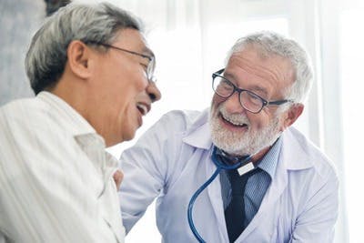 médecin et patient ayant subi un AVC s'amusant à discuter du traitement de l'AVC