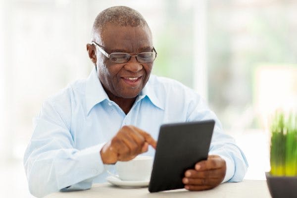 senior man doing cognitive rehabilitation exercises on tablet to improve memory after stroke