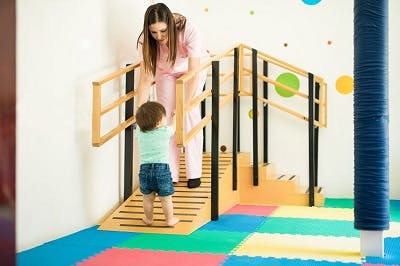 toddler with spastic diplegia practicing walking at pediatric physical therapy