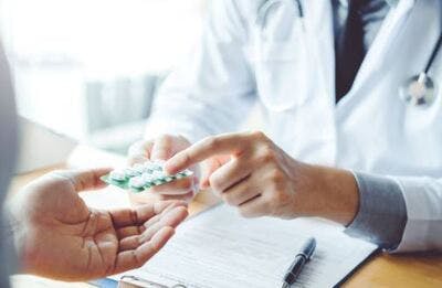 Arzt übergibt einem Schlaganfallpatienten eine Blisterpackung mit Aspirin
