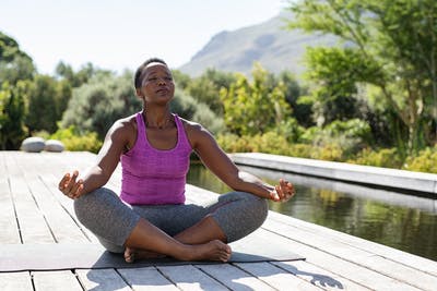 stroke survivor sitting on yoga mat meditating outside