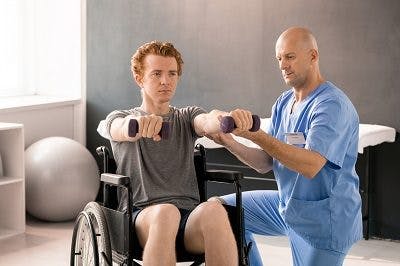 adult male with cerebral palsy participating in physical therapy