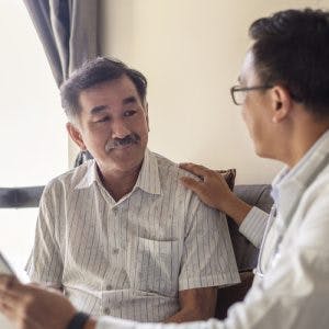 doctor talking to patient with agnosia holding up tablet