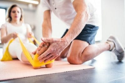 physiotherapist helping patient with dorsiflexion for relearning to walk after brain injury