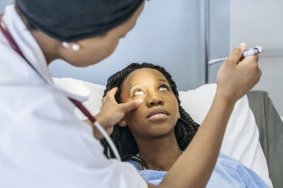 doctor checking for eye reflex in patient with diffuse axonal injury