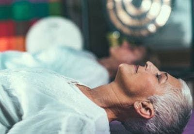 woman lying peacefully on her back doing mental practice