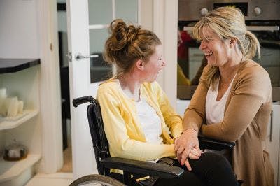 mother smiling at her daughter with cerebral palsy