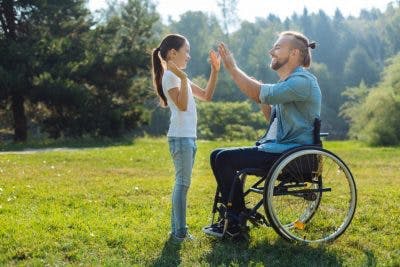 TBI survivor in wheelchair giving a high five