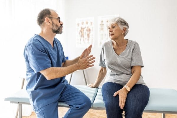 doctor sitting next to patient explaining how long after head injury can symptoms occur