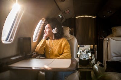 woman gazing out of airplane window to reduce sensory overload while flying after brain injury