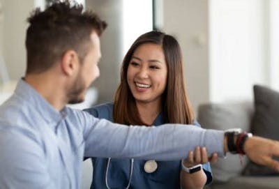 occupational therapist working with cerebellum brain injury patient on arm exercises