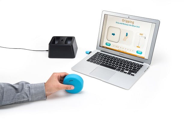 Person holding blue FitMi "puck" while following along to the neurorehabilitation devices software