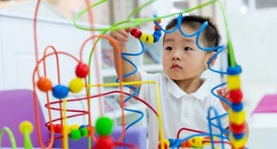 small child with traumatic brain injury doing a puzzle to work on fine motor skills during recovery