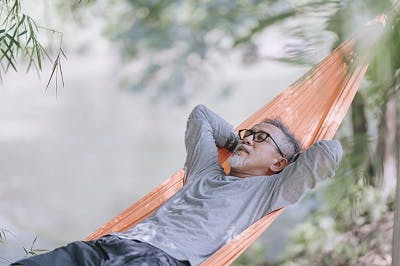 man with post traumatic hypersomnia enjoying quality sleep outdoors