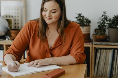woman writing in gratitude journal to help cope with brain injury and depression
