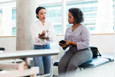 therapist explaining to survivor what hand exercises for spinal cord injury are most effective