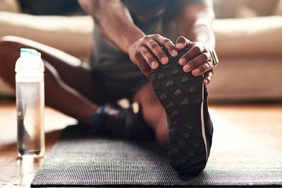 man stretching for his spinal cord injury exercises at home