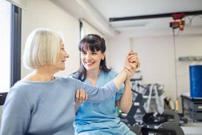 therapist helping survivor with passive upper body exercises after spinal cord injury