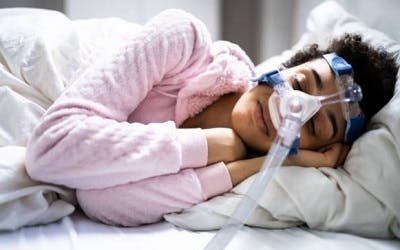 woman sleeping with cpap to help manage breathing difficulties after spinal cord injury