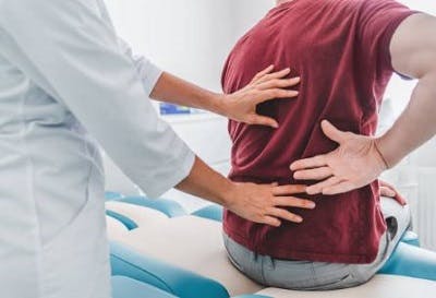 patient showing doctor where his symptoms of spinal stroke are