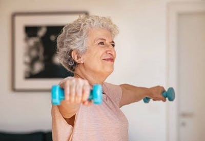Survivor doing arm exercises from her home exercise program for stroke recovery.