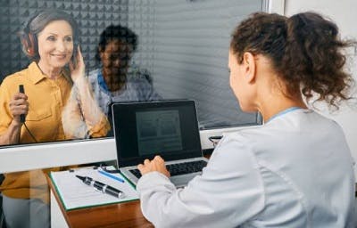 audiologist performing a hearing test on survivor to confirm tinnitus after head injury