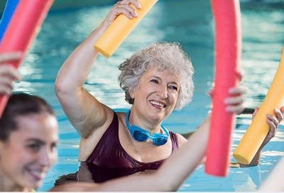 survivor happily performing pool exercises for spinal cord injury