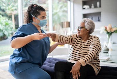 Therapist helping survivor accomplish her home exercise program for stroke recovery.