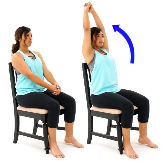 woman with hands clasped sitting in chair raiser her arms overhead