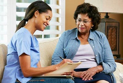 Caregiver helping TBI survivor with a cognitive speech therapy activity at home.