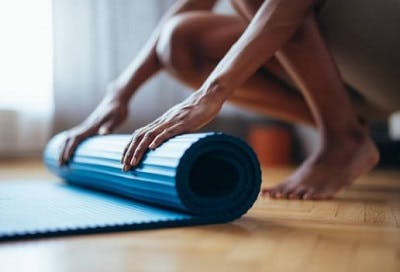 Spinal cord injury survivor rolling his mat to exercise.