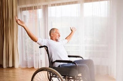 Patient in a wheelchair performing half jumping jacks, a shoulder exercise for spinal cord injury.