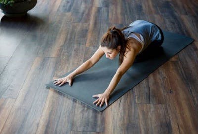 Survivor engaging in a mat exercise for spinal cord injury.