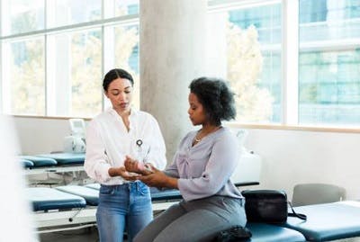 therapist helping patient overcome a post-traumatic tremor