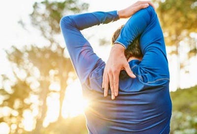 Illustration of the overhead shoulder stretch, an upper extremity exercise after spinal cord injury.