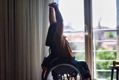 Survivor safely performing spinal cord injury shoulder exercises in a wheelchair.