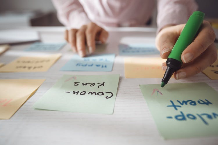 woman writing details on sticky notes to help with brain injury organization skills